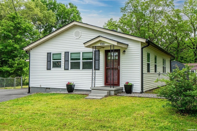 view of front of property with fence, crawl space, and a front lawn