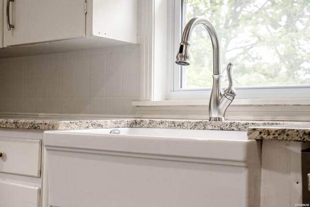 room details featuring a sink, white cabinets, and light countertops