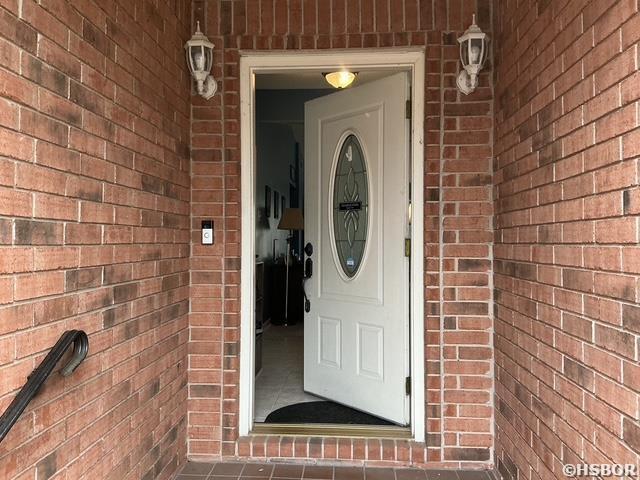 view of exterior entry with brick siding