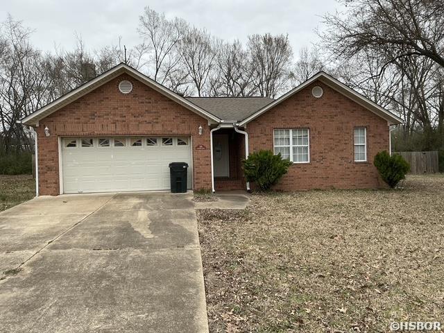 ranch-style home with brick siding, a garage, and driveway