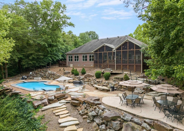 pool featuring a sunroom and a patio