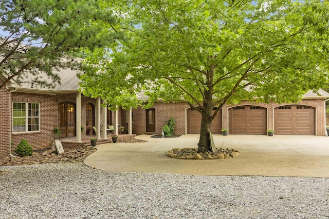 view of property hidden behind natural elements with concrete driveway, brick siding, an attached garage, and roof with shingles