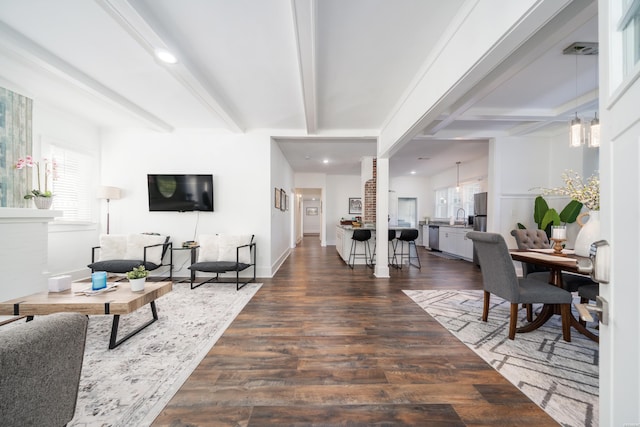 living area featuring recessed lighting, baseboards, beamed ceiling, dark wood finished floors, and an inviting chandelier