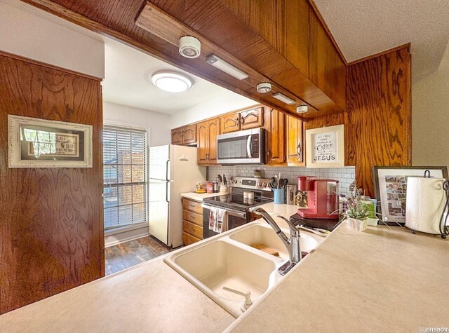 10 Steeplechase Ct, Hot Springs, AR 71901 - kitchen with appliances with stainless steel finishes, brown cabinets, backsplash, light countertops, and a sink