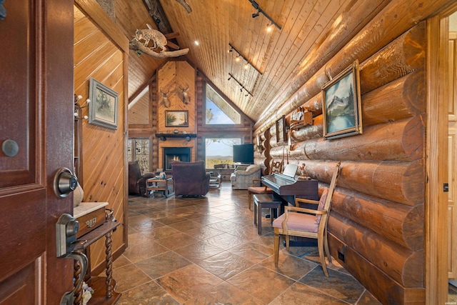 home office with high vaulted ceiling, wood ceiling, a lit fireplace, rustic walls, and rail lighting