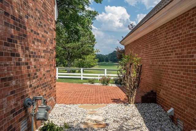 exterior space featuring a patio area, brick siding, and fence