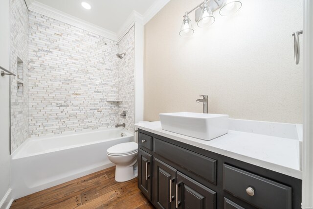 bathroom featuring toilet, wood finished floors, bathtub / shower combination, crown molding, and vanity
