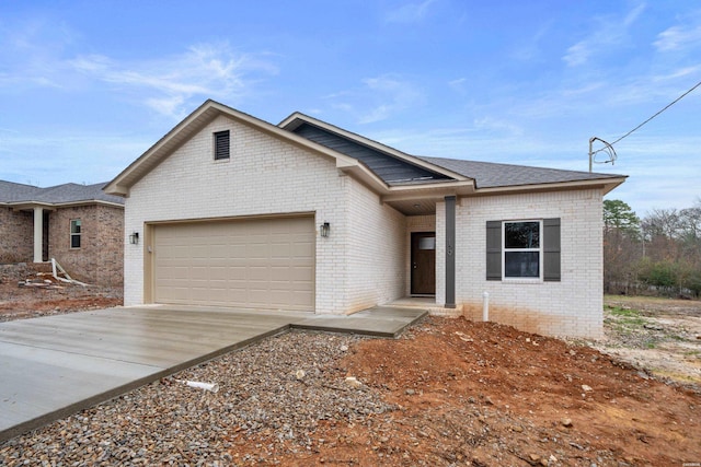 ranch-style house featuring an attached garage, driveway, and brick siding