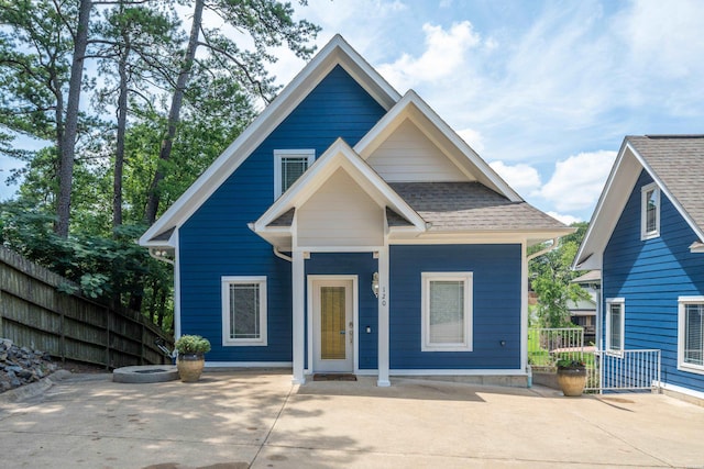 view of front of home featuring roof with shingles and fence