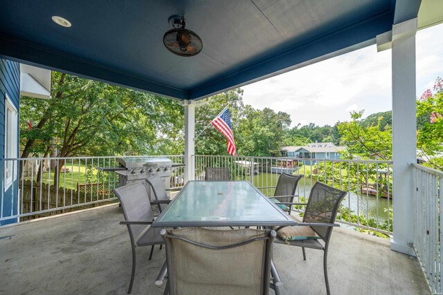 view of patio / terrace with outdoor dining space, a water view, and ceiling fan