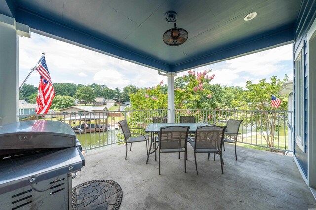 view of patio with outdoor dining space, a water view, and a grill