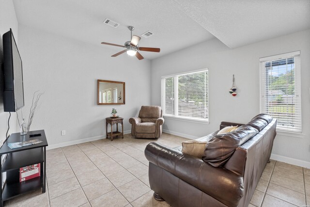 living room with visible vents, a textured ceiling, baseboards, and light tile patterned flooring