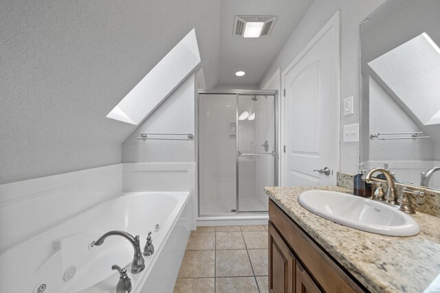 bathroom with a skylight, vanity, a shower stall, tile patterned floors, and a tub with jets