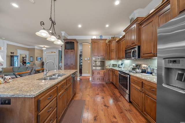 kitchen featuring a sink, ornamental molding, backsplash, and stainless steel appliances