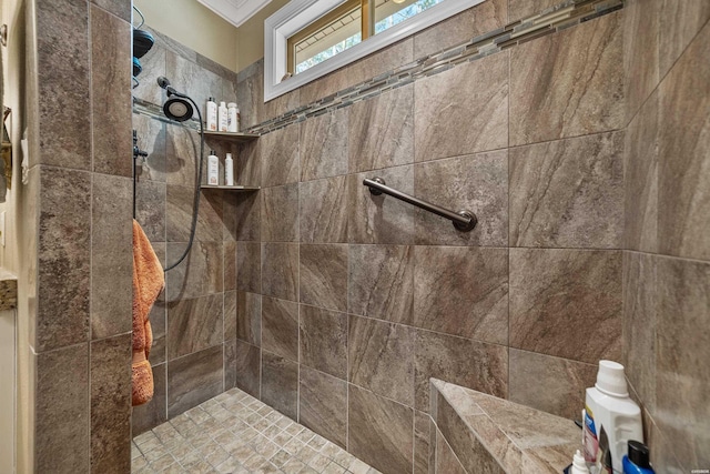 full bathroom featuring crown molding and tiled shower