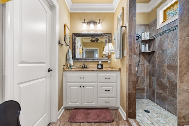 full bath featuring vanity, crown molding, baseboards, and walk in shower