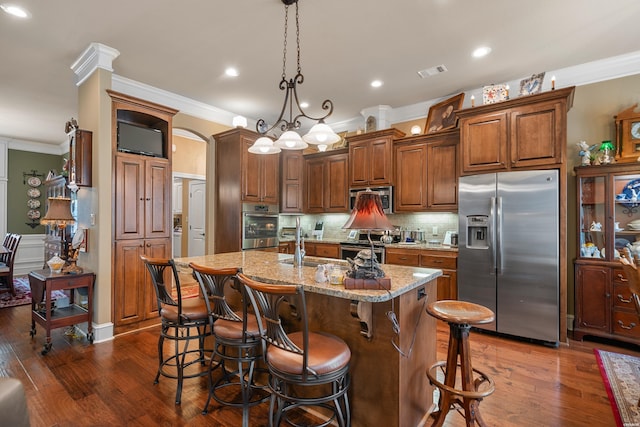 kitchen with light stone countertops, visible vents, appliances with stainless steel finishes, crown molding, and tasteful backsplash