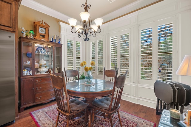 dining space with a chandelier, dark wood-style floors, and ornamental molding