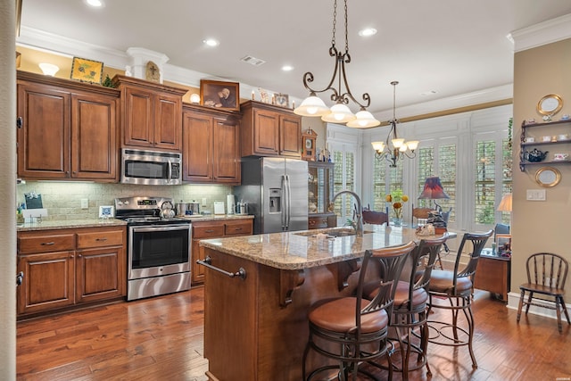 kitchen featuring dark wood finished floors, a sink, ornamental molding, stainless steel appliances, and tasteful backsplash