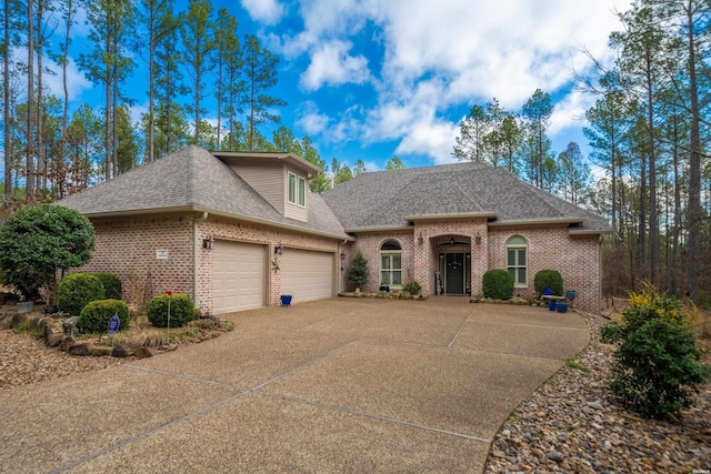 view of front of home with brick siding, roof with shingles, concrete driveway, and an attached garage