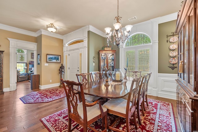 dining room featuring visible vents, plenty of natural light, a notable chandelier, and wood finished floors