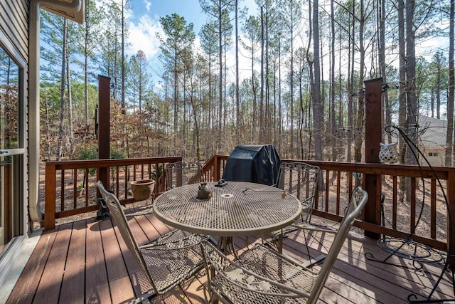 deck with grilling area and outdoor dining area