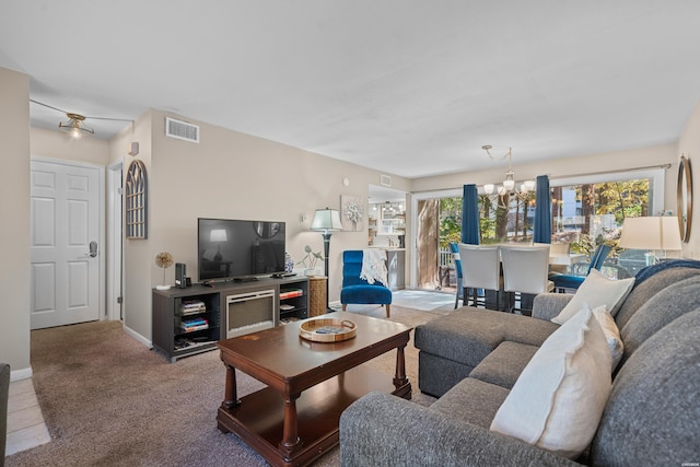 carpeted living room featuring baseboards, visible vents, and a chandelier