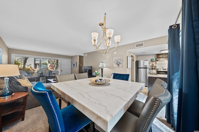 dining area featuring visible vents and a chandelier