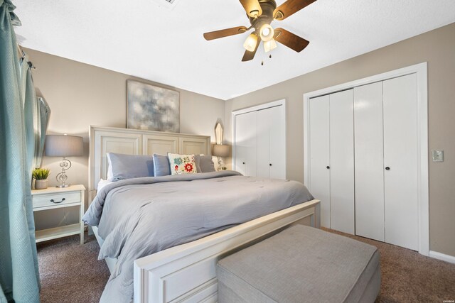 carpeted bedroom featuring ceiling fan and multiple closets