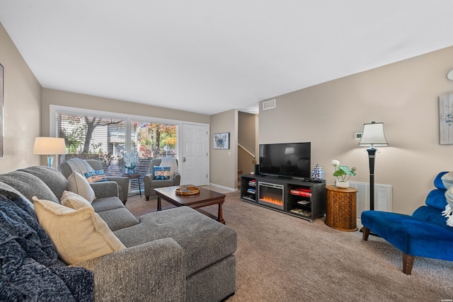 living room with carpet floors, visible vents, and baseboards