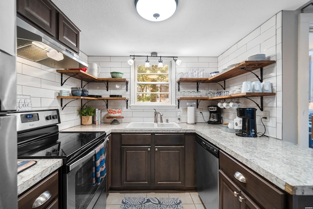 kitchen featuring extractor fan, dark brown cabinetry, a sink, appliances with stainless steel finishes, and tasteful backsplash