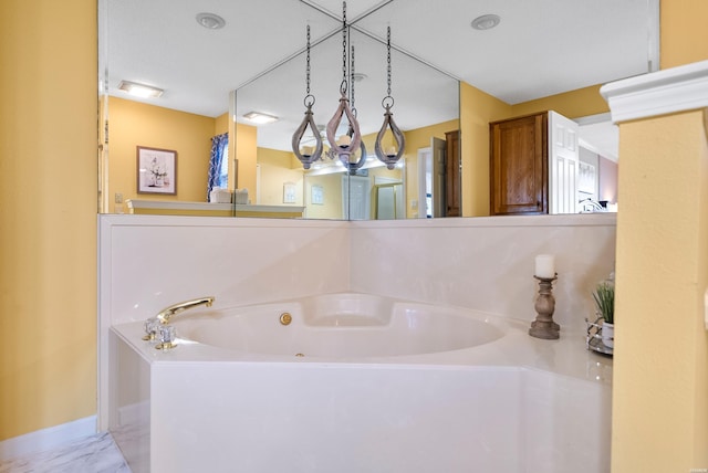 bathroom featuring marble finish floor, a garden tub, and baseboards