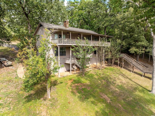 back of house with ceiling fan, a chimney, stairs, a deck, and a yard