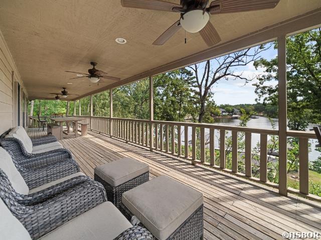 wooden deck featuring a water view and ceiling fan