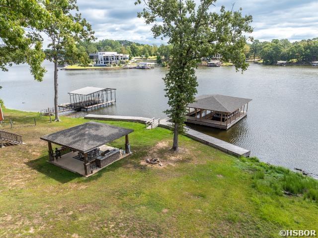 view of dock featuring a yard, a water view, and a gazebo