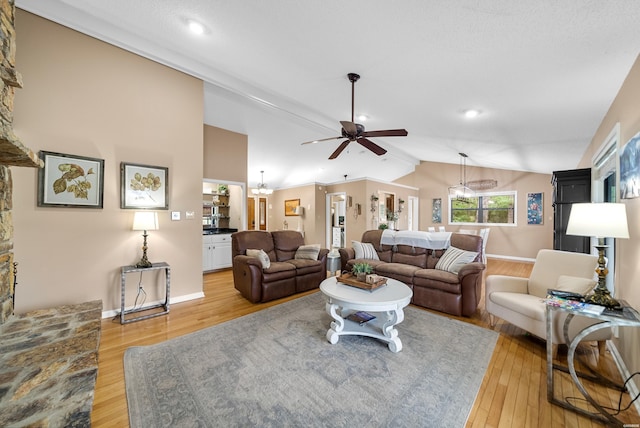 living area featuring light wood-type flooring, lofted ceiling, baseboards, and a ceiling fan