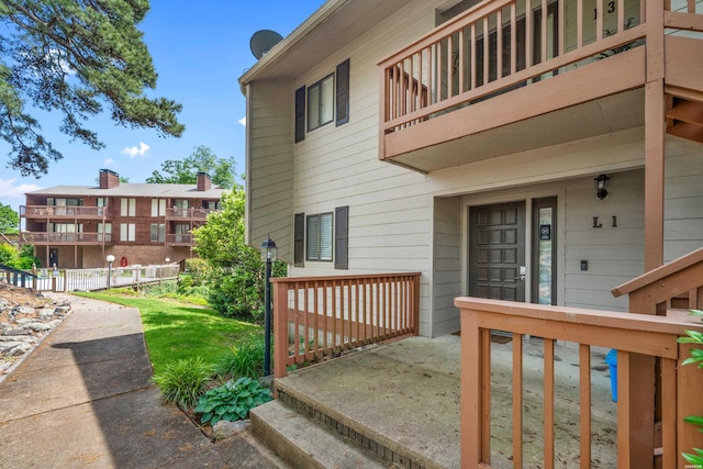 view of home's exterior featuring a balcony and fence