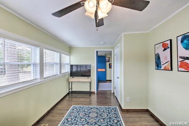 hallway featuring crown molding, baseboards, and dark wood-style flooring