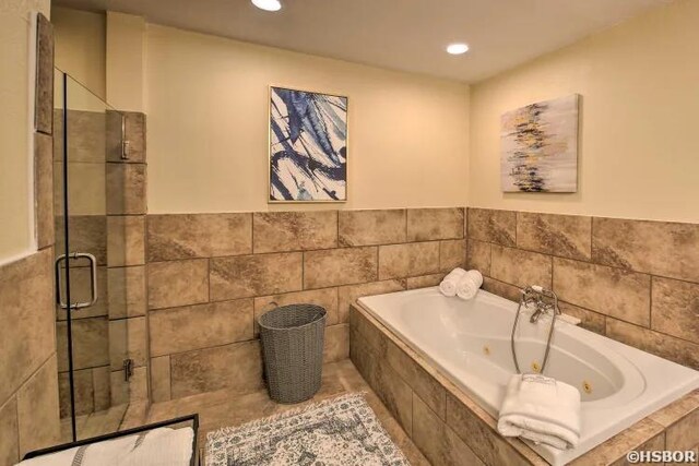 full bath featuring a tub with jets, a stall shower, and recessed lighting