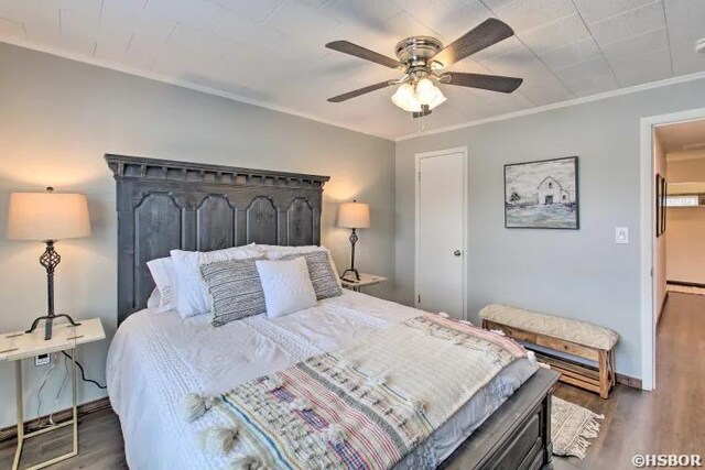 bedroom with dark wood-style flooring, crown molding, baseboards, and ceiling fan