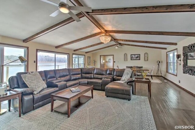 living area featuring lofted ceiling with beams, wood finished floors, a wealth of natural light, and baseboards