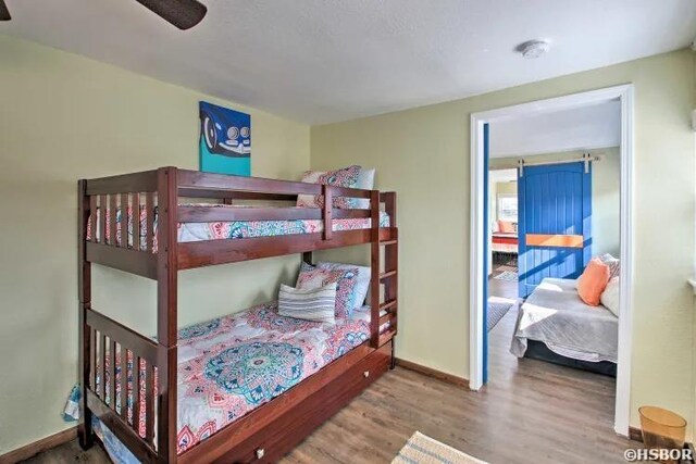 bedroom featuring wood finished floors and baseboards