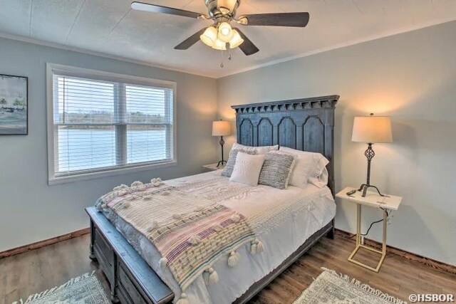 bedroom featuring dark wood-style floors, ceiling fan, crown molding, and baseboards