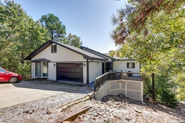 view of front facade with a garage, driveway, and a wooden deck