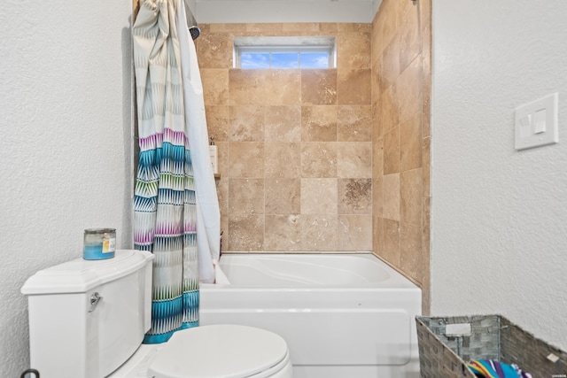 full bathroom with a textured wall, toilet, and shower / tub combo