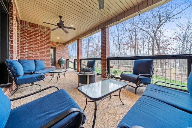 view of patio / terrace featuring a ceiling fan and an outdoor living space with a fire pit