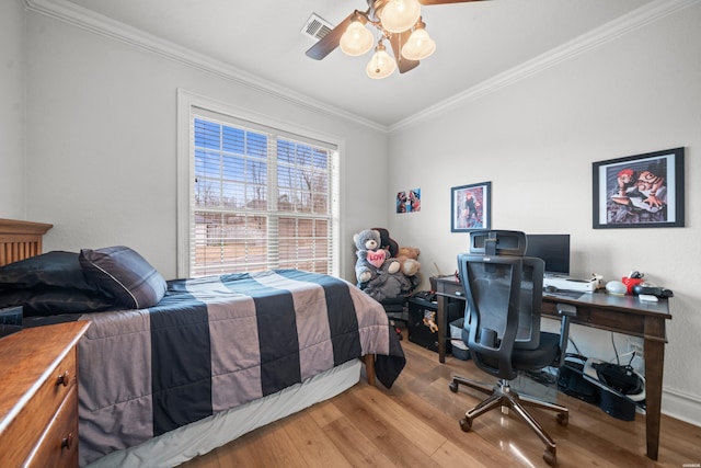 bedroom featuring visible vents, light wood-style flooring, crown molding, and ceiling fan