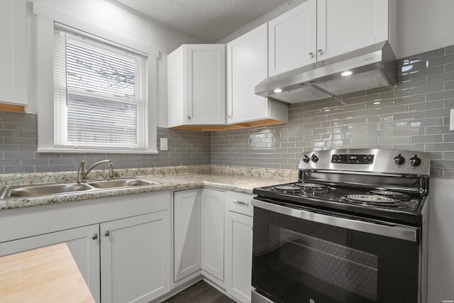 kitchen with electric range, a sink, light countertops, under cabinet range hood, and white cabinetry