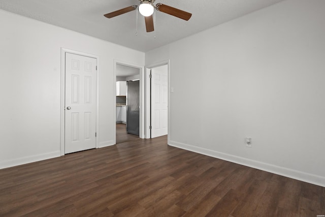 unfurnished bedroom featuring a ceiling fan, dark wood-type flooring, and baseboards