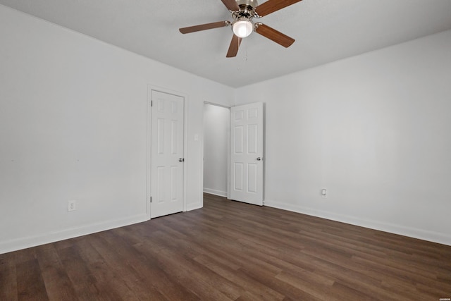 unfurnished room featuring dark wood-style floors, baseboards, and ceiling fan